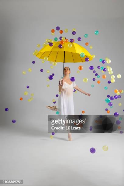 colorful balls are raining from the sky. beautiful ballerina is protected from colorful balls with her japanese umbrella. - 101cats stock pictures, royalty-free photos & images