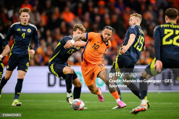 Memphis Depay of the Netherlands is tackled by Jack Hendry and Ryan Porteous of Scotland during the friendly match between Netherlands and Scotland...