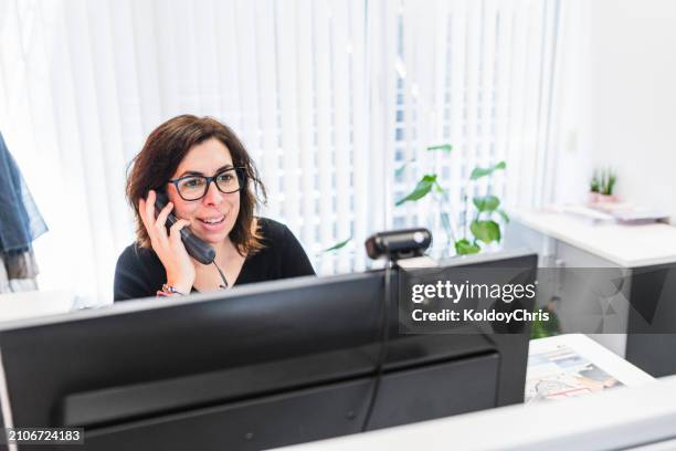 confident businesswoman multi-tasking with a phone call and computer work - coordinator stock pictures, royalty-free photos & images