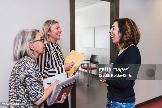 colleagues sharing a laugh in a relaxed office environment - colleague engagement stock pictures, royalty-free photos & images