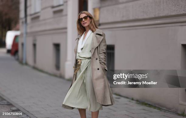 Viviane Geppert seen wearing Miu Miu gold / black sunglasses, Miu Miu pastel green flattered midi dress and Miu Miu beige / brown trenchcoat / long...