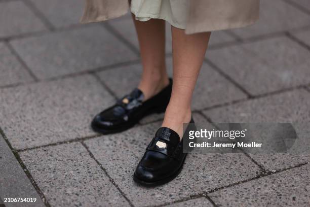 Viviane Geppert seen wearing Miu Miu shiny black loafers, on March 22, 2024 in Munich, Germany.