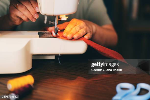 female designer stitching fabric through sewing machine - nähen stock-fotos und bilder