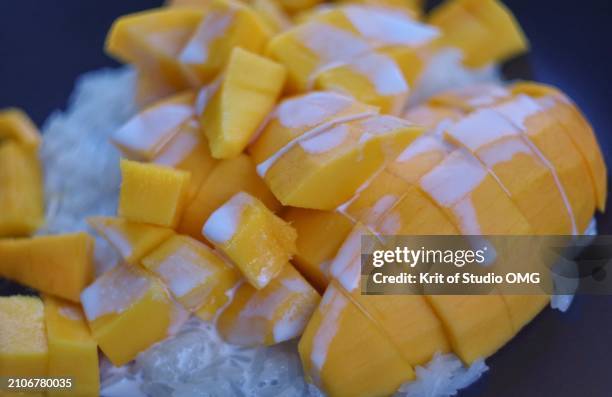 sticky rice coconut milk with mango on the black plate - mangue photos et images de collection