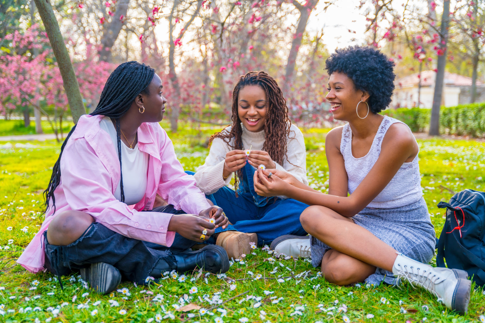 African friends chatting sitting on a park in spring African friends chatting sitting on a park in spring