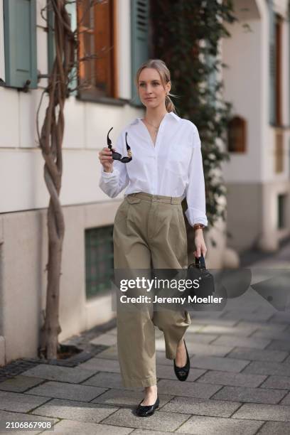 Marlies Pia Pfeifhofer seen wearing Versace black sunglasses, gold earrings and necklace, LaMarel white cotton buttoned blouse shirt, Agolde beige...