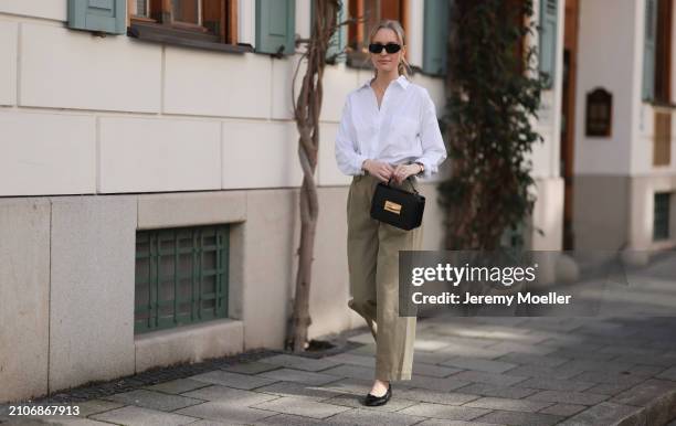 Marlies Pia Pfeifhofer seen wearing Versace black sunglasses, gold earrings and necklace, LaMarel white cotton buttoned blouse shirt, Agolde beige...