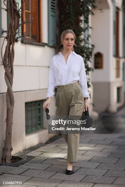 Marlies Pia Pfeifhofer seen wearing Versace black sunglasses, gold earrings and necklace, LaMarel white cotton buttoned blouse shirt, Agolde beige...