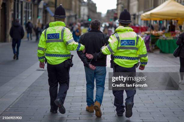 Man is led away by police after he confronted demonstrators who gathered to take part in a mass funeral procession protest to commemorate the...
