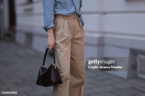 Marlies Pia Pfeifhofer seen wearing Citizen of Humanity light blue denim blouse / buttoned shirt, Andiata beige wide leg suit pants and Tods dark...