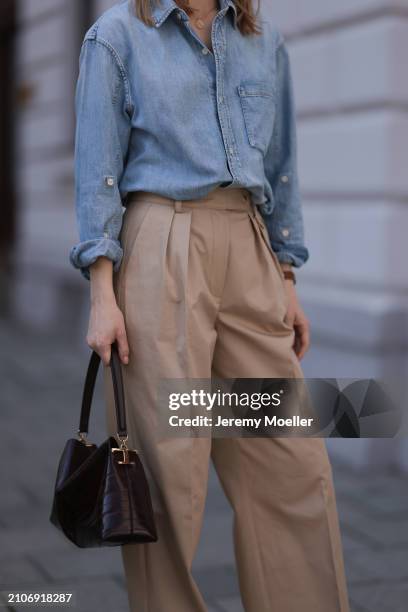 Marlies Pia Pfeifhofer seen wearing Citizen of Humanity light blue denim blouse / buttoned shirt, Andiata beige wide leg suit pants and Tods dark...