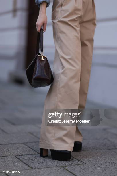 Marlies Pia Pfeifhofer seen wearing Andiata beige wide leg suit pants, Tods dark brown leather bag and Lola Cruz black shiny leather plateau heeled...