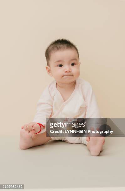 asian chinese infant with casual cloth playing in the ground - lynnhsin stock-fotos und bilder