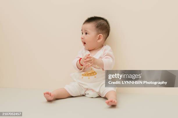 asian chinese infant with casual cloth playing on the ground - lynnhsin stock-fotos und bilder