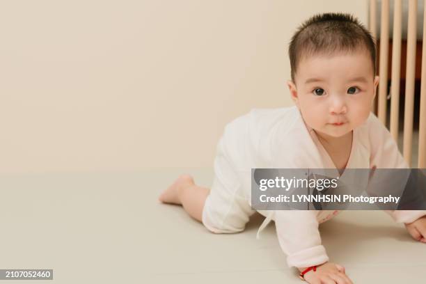 asian chinese infant with casual cloth playing in the ground - geburtsanzeige stock-fotos und bilder