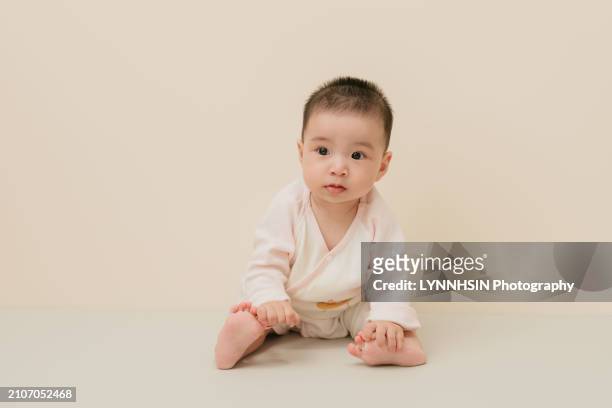 asian chinese infant with casual cloth playing on the ground - lynnhsin stock-fotos und bilder