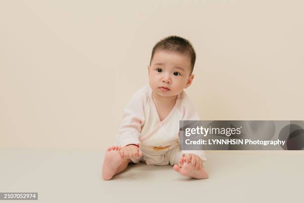 asian chinese infant with casual cloth playing on the ground - lynnhsin stock-fotos und bilder