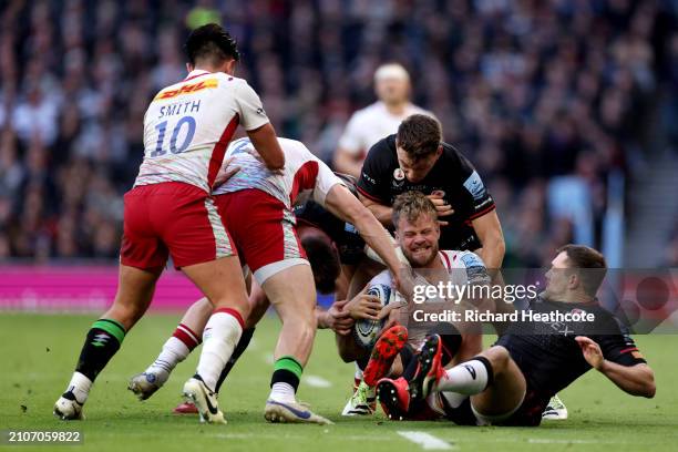 Nick Tompkins, Alex Goode and Alex Lewington of Saracens tackle Tyrone Green of Harlequins during the Gallagher Premiership Rugby match between...