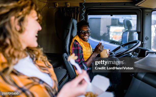 two truck drivers eating on lunch break - truck cockpit stock pictures, royalty-free photos & images