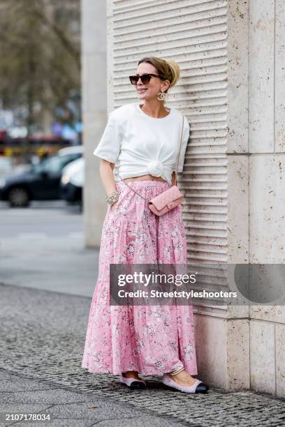 Tamara von Nayhauss, wearing a long rose colored skirt with flowers by Susanne Benter, a white T-shirt with a knot and shoulder pads by Magda Butrym,...