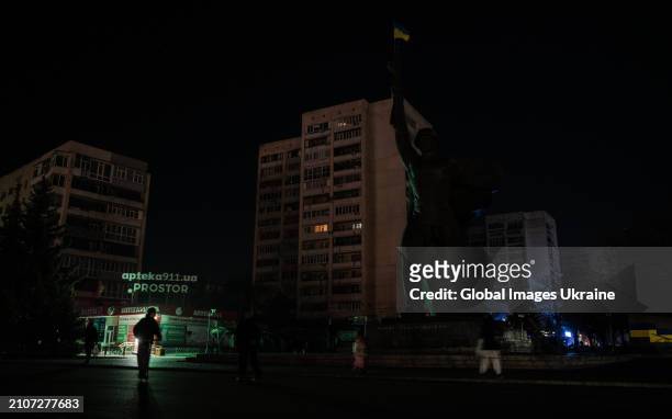 People walk down a street during a power outage caused by a Russian missile strike on the city's energy sector on March 22, 2024 in Kharkiv, Ukraine....