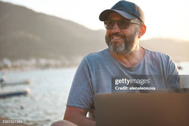 mature adult man traveler ( with laptop) - one embankment stock pictures, royalty-free photos & images