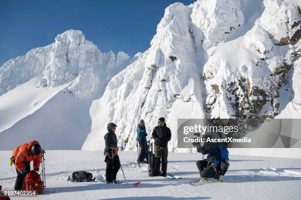 adventure photographer prepares to shoot on mountain - professional skier stock pictures, royalty-free photos & images