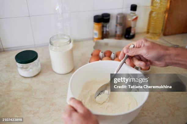 man's hands mix flour, sugar and salt in a bowl. homemade food cooking concept. - adding salt stock pictures, royalty-free photos & images