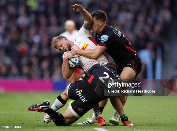 Alex Goode and Alex Lewington of Saracens tackle Tyrone Green of Harlequins during the Gallagher Premiership Rugby match between Saracens and...