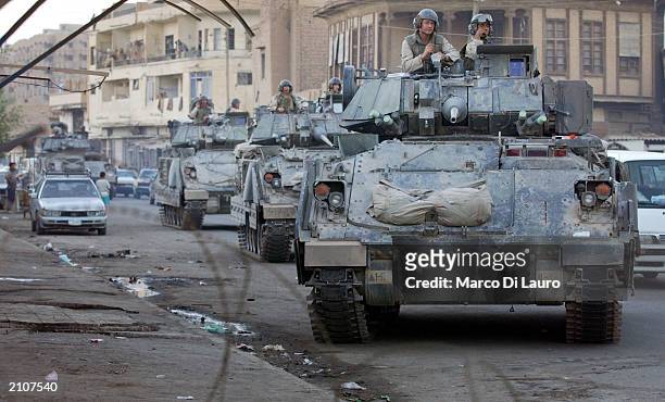 Armored vehicles from the U.S Army's 1st Armored Division patrol streets June 23, 2003 in the Alshek-Maruf neighborhood of Baghdad, Iraq. About 900...