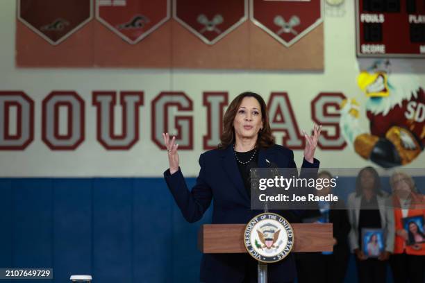 Vice President Kamala Harris speaks to the media as family members hold portraits of their loved ones who were killed during the 2018 shooting at...