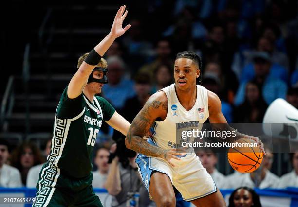 Armando Bacot of the North Carolina Tar Heels dribbles the ball against Carson Cooper of the Michigan State Spartans in the first half in the second...