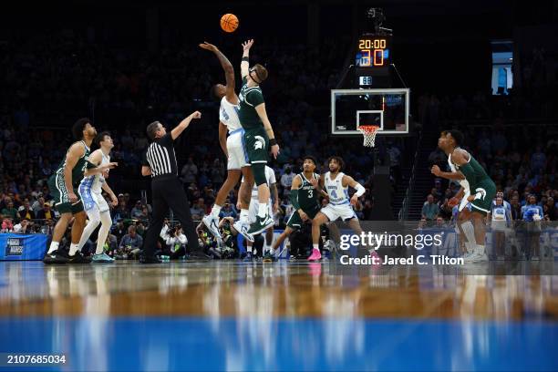 Armando Bacot of the North Carolina Tar Heels reaches for the tipoff ball against Carson Cooper of the Michigan State Spartans during the first half...
