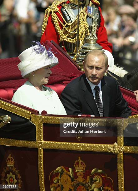 Russian President Vladimir Putin is accompanied by Her Majesty The Queen during a procession at The Mallat during the start iof his state visit on...