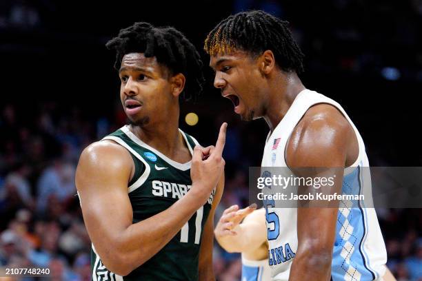 Harrison Ingram of the North Carolina Tar Heels celebrates a play as A.J. Hoggard of the Michigan State Spartans reacts during the first half in the...