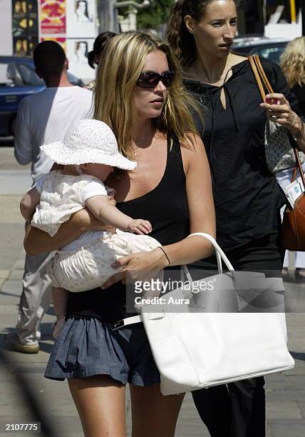 Model Kate Moss walks with her baby daughter Lola in Notting Hill June 24, 2003 in West London.