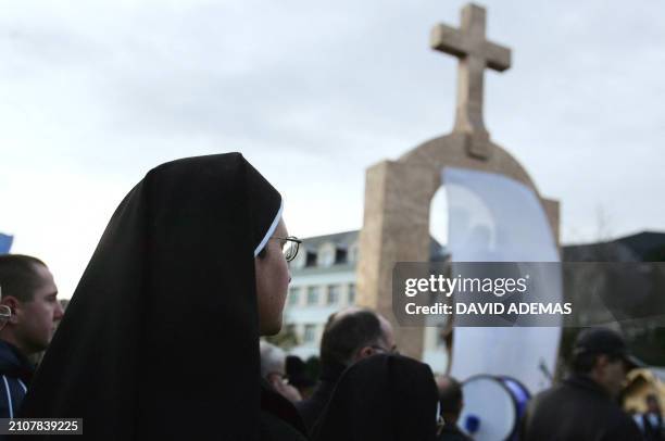 Une religieuse se tient devant la statue du pape Jean Paul II, recouverte d'un voile, le 10 décembre 2006 à Ploërmel, juste avant son inauguration....