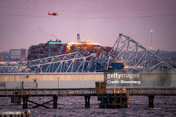 Coast Guard helicopter flies over the Dali container vessel after it struck the Francis Scott Key Bridge that collapsed into the Patapsco River in...