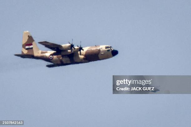 This picture taken from Israel's southern border with the Gaza Strip shows an Egyptian Air Force C-130 Hercules turboprop military transport aircraft...