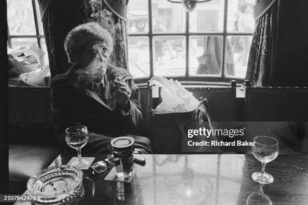 Woman smokes a cigarette in a Baneswell pub, Newport, Wales, on 18th April 1985.