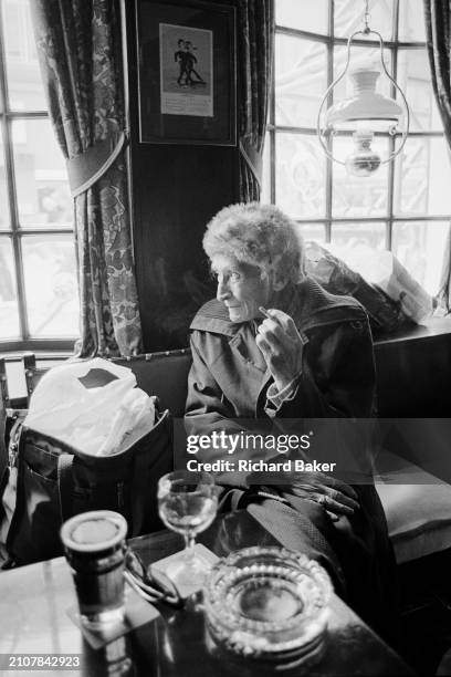 Woman smokes a cigarette in a Baneswell pub, Newport, Wales, on 18th April 1985.