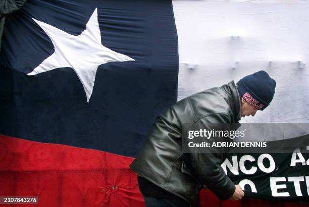 An anti-Pinochet protester pins up a banner outside the Royal Courts of Justice in London 08 February 2000. The legal conundrum continues over the...