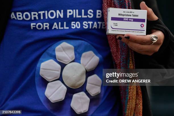 Pro-abortion rights activist holds a box of mifepristone during a rally in front of the US Supreme Court on March 26 in Washington, DC. The Court...