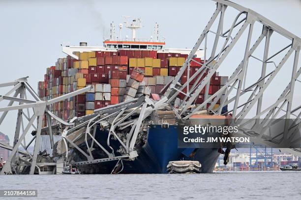 The steel frame of the Francis Scott Key Bridge sits on top of the container ship Dali after the bridge collapsed, Baltimore, Maryland, on March 26,...