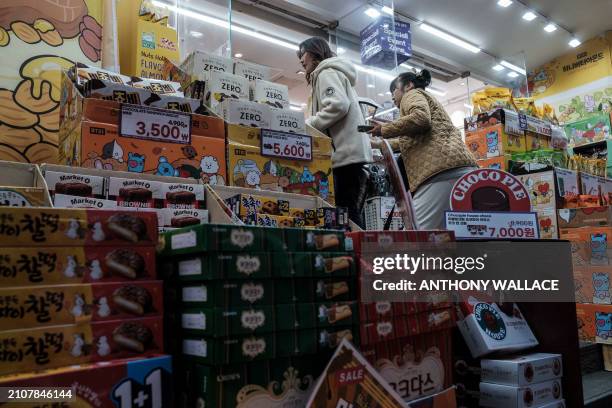 Customers enter a confectionary shop in the Myeongdong shopping district of Seoul on March 26, 2024.