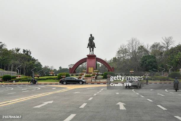 Cars drive past the statue of General Aung San in Naypyidaw on March 26, 2024. Myanmar's junta prepared to put on a show of force at the annual Armed...