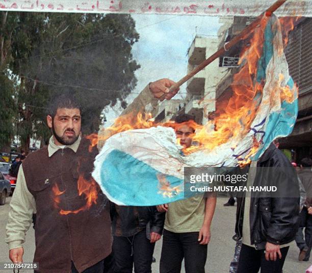 Lebanese students burn an Israeli flag in the southern market town of Nabatiyeh during a demonstration 22 February 2000 against Israel's latest...