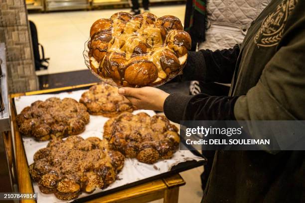 Bakery worker displays "Maarouk", a sweet pastry usually stuffed with dates or other sweet fillings consumed during the Muslim holy fasting month of...