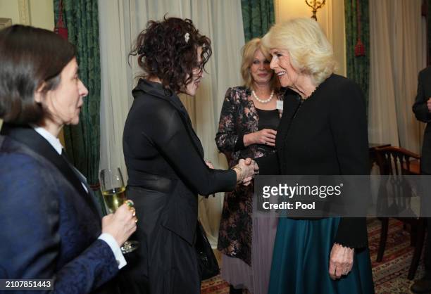 Queen Camilla speaks to Helena Bonham Carter during a reception to mark the findings of a new research study commissioned by The Queen's Reading Room...