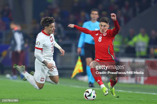 Nicola Zalewski of Poland tackled by Harry Wilson of Wales during the UEFA EURO 2024 Play-Offs semifinal match between Wales and Poland at Cardiff...